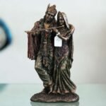 A beautiful and intricate bronze statue depicting Radha and Krishna, two central deities in Hinduism.